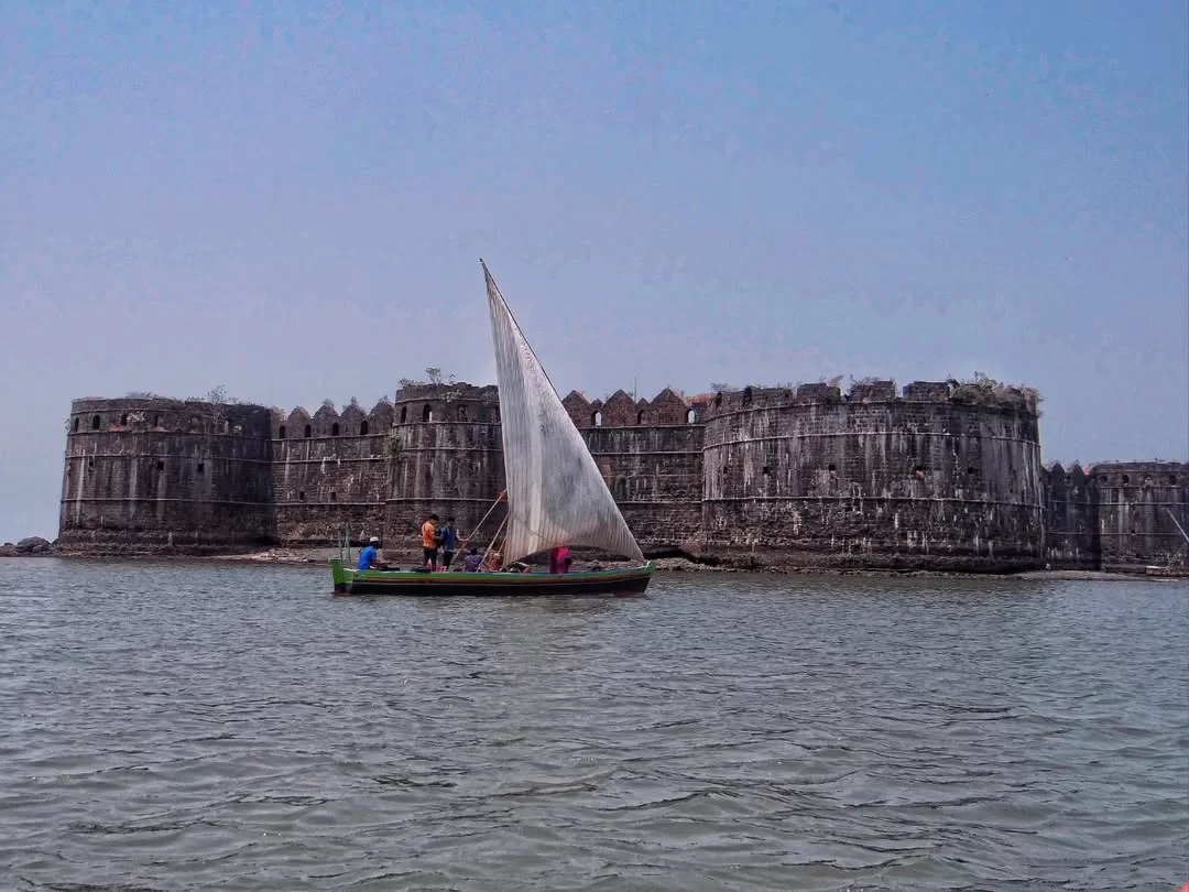 Murud-Janjira Fort Maharashtra Arabian Sea green boat white sail locals approaching massive black stone battlements sea water horizon blue sky; historic unconquered island coastal heritage photography package.
