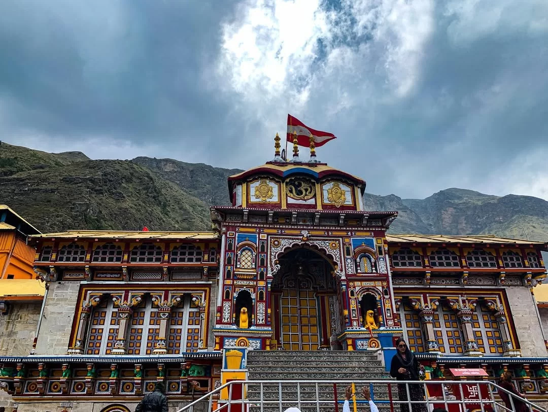 Badrinath Temple Uttarakhand during cloudy day, featuring intricate architecture and Himalayan mountains, perfect spiritual experience Uttarakhand tour packages.