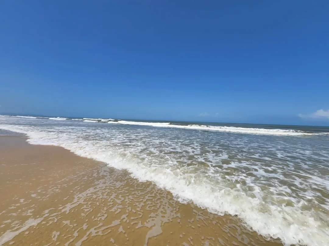 Serene Betalbatim Beach Goa sunny day, featuring golden sand gentle waves turquoise Arabian Sea clear blue sky, perfect South Goa beach tour package. 