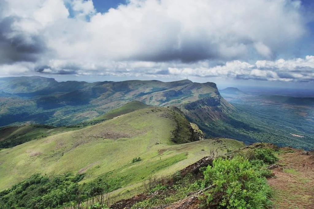Baba Budangiri in Chikkamagaluru during daylight, featuring rolling hills and panoramic mountain views, perfect adventure experience, Karnataka tour packages.