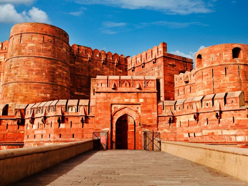 Agra Fort Uttar Pradesh red sandstone Amar Singh Gate towers blue sky UNESCO heritage Taj Mahal view, perfect Golden Triangle heritage package.