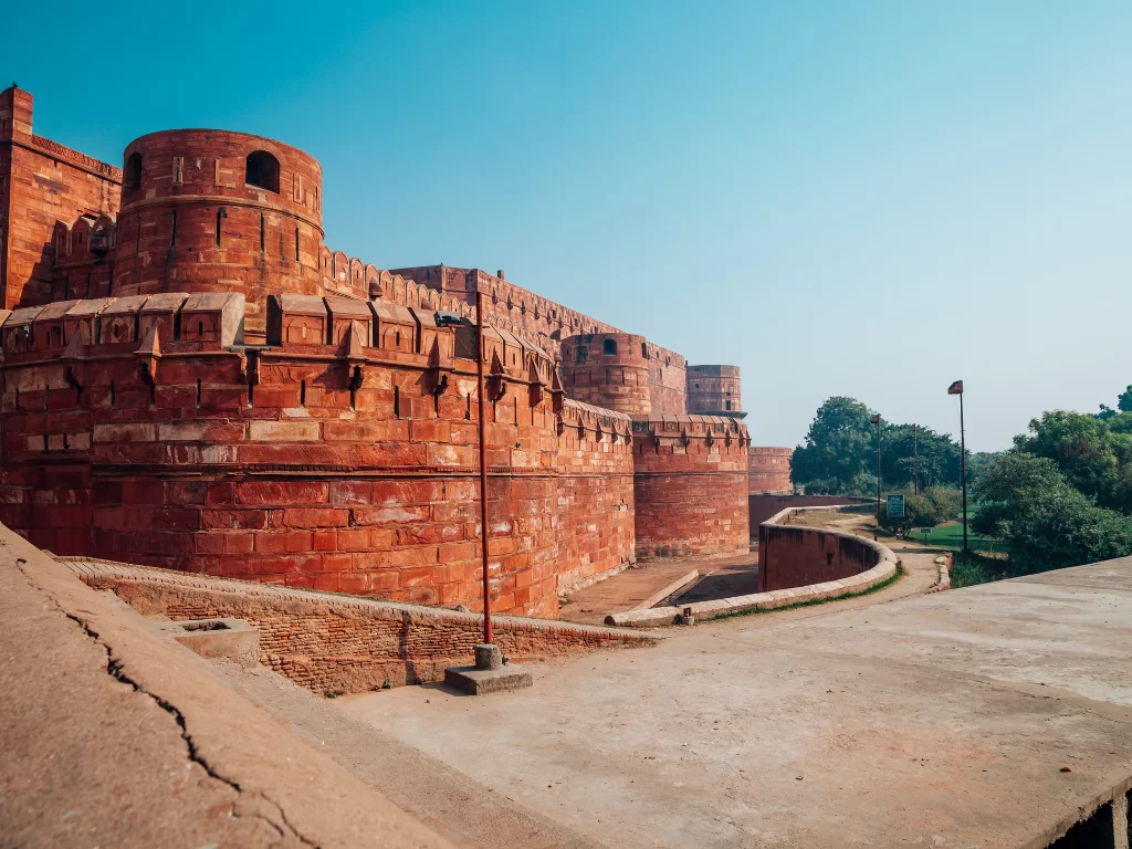 Agra Fort Uttar Pradesh red sandstone bastions towers ramp walkway trees flagpole blue sky Yamuna River view UNESCO heritage, perfect Golden Triangle heritage package.