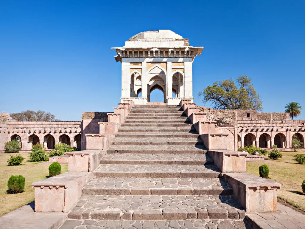 Ashrafi Mahal Victory Tower at Mandu under clear skies, featuring grand staircase and arched pavilion, perfect heritage experience with Madhya Pradesh tour packages.