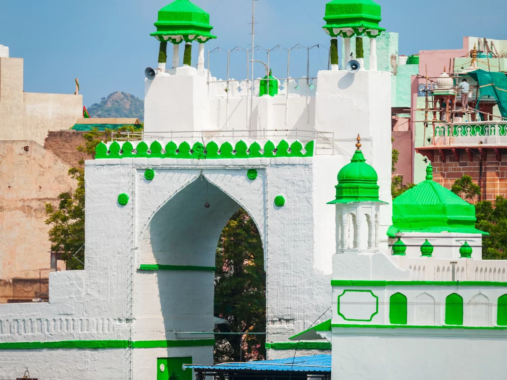 Ajmer Sharif Dargah Nizam Gate white structure green domes minarets arches intricate Islamic architecture urban Rajasthan India Khwaja Moinuddin Chishti Sufi shrine entrance.