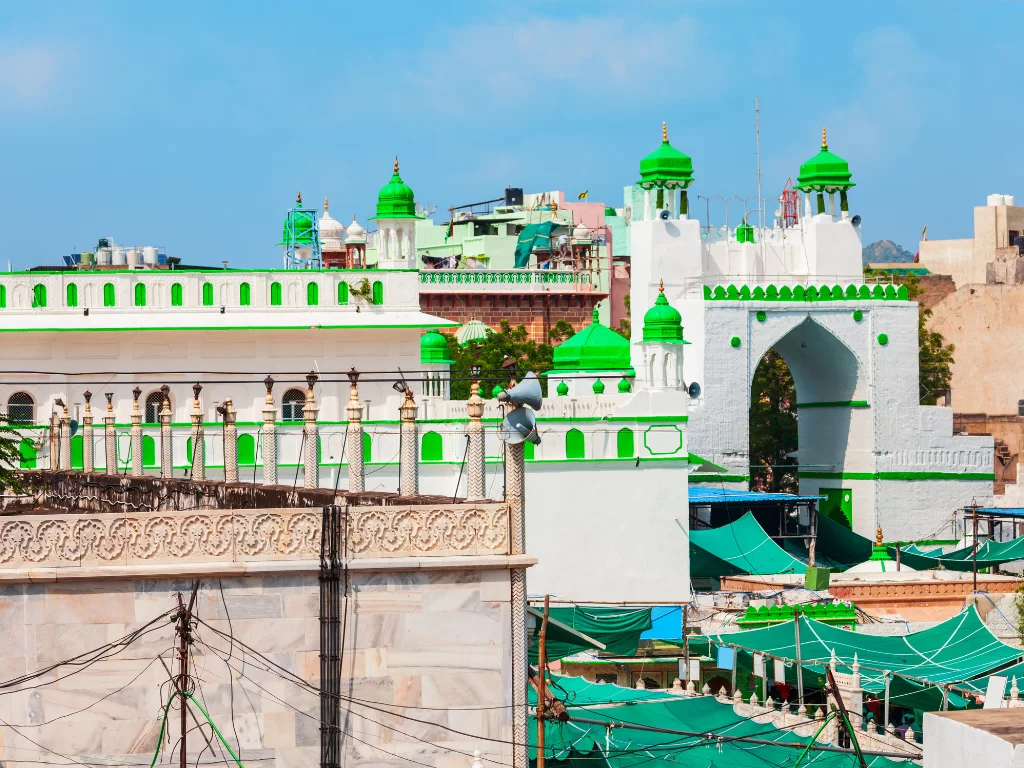Ajmer Sharif Dargah white buildings green domes minarets arches railings markets tents Khwaja Moinuddin Chishti Sufi shrine complex Rajasthan India historic Islamic architecture.
