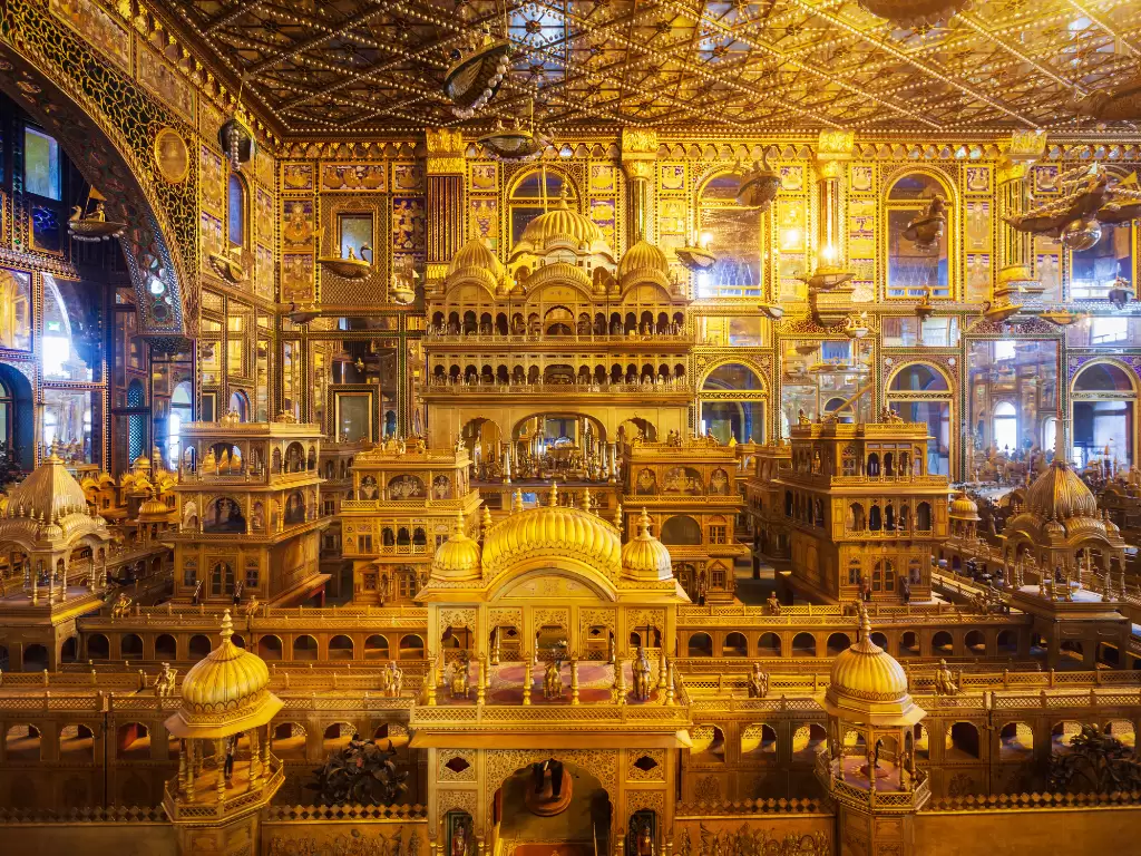 Golden miniature temple model at Ajmer Soniji ri Jain Temple Rajasthan in warm lighting, featuring intricate domes arches and ornate ceilings, perfect spiritual Rajasthan tour package.