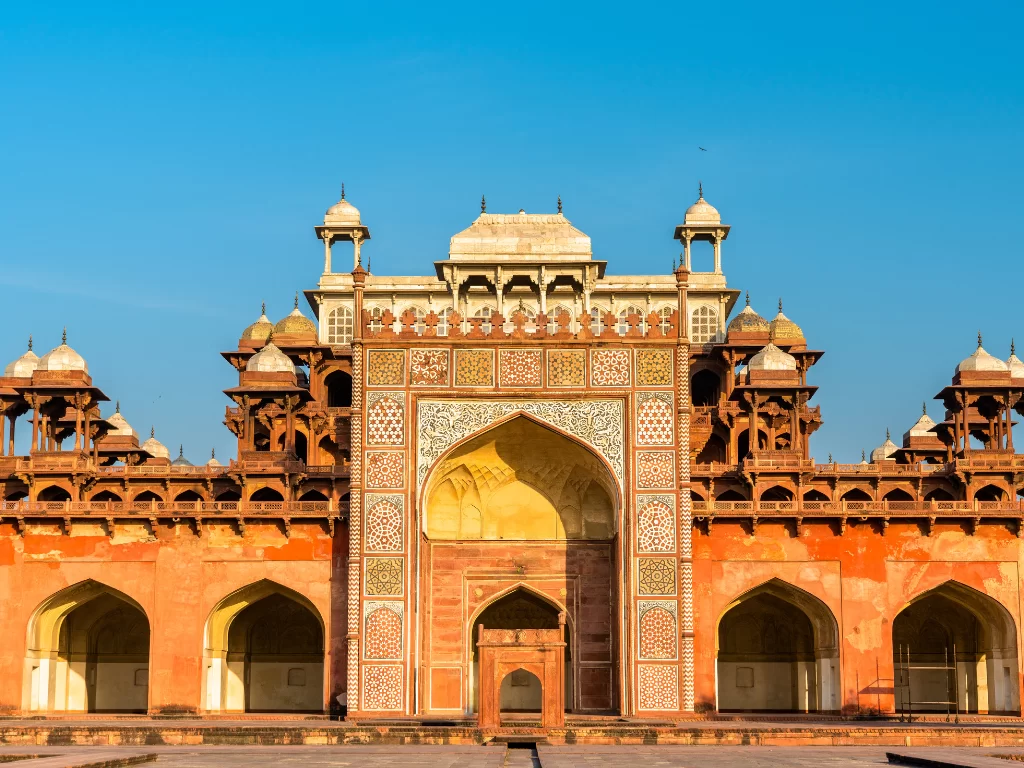 Akbar's Tomb Agra Uttar Pradesh grand entrance red sandstone inlays white marble minarets domes intricate jali work blue sky Mughal architecture UNESCO heritage site, perfect Golden Triangle heritage tour package.