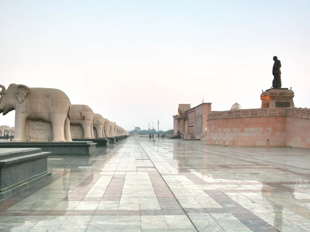 Ambedkar statue with elephants at memorial park Lucknow during misty morning, featuring plaza reflections sunset glow, perfect cultural Uttar Pradesh tour package.