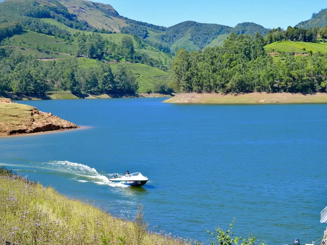 Anamudi Mattupetty Dam in Munnar with scenic hills, lush greenery and boating on serene reservoir.