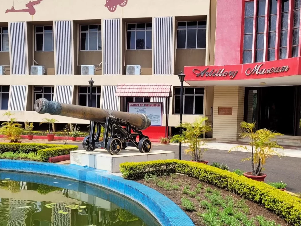 Historic cannon display outside Artillery Museum Nashik Maharashtra with landscaped garden and museum building facade in background