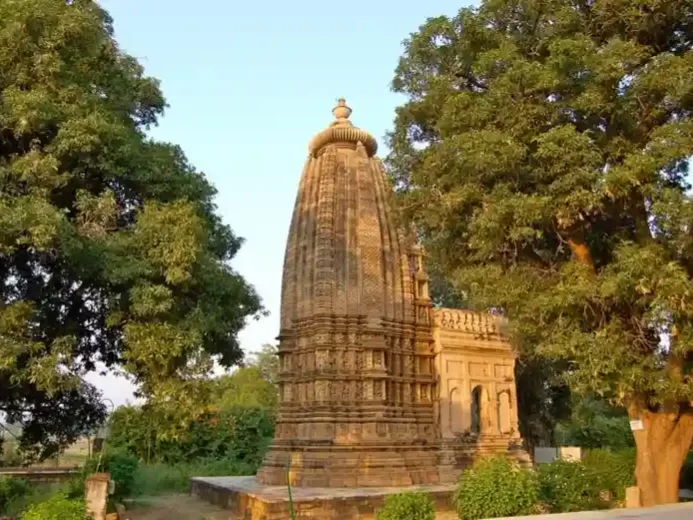 Asri Adinath Digambar Jain Mandir in Madhya Pradesh with intricately carved stone shikhara surrounded by lush trees, a serene heritage temple often featured in Madhya Pradesh tour packages.