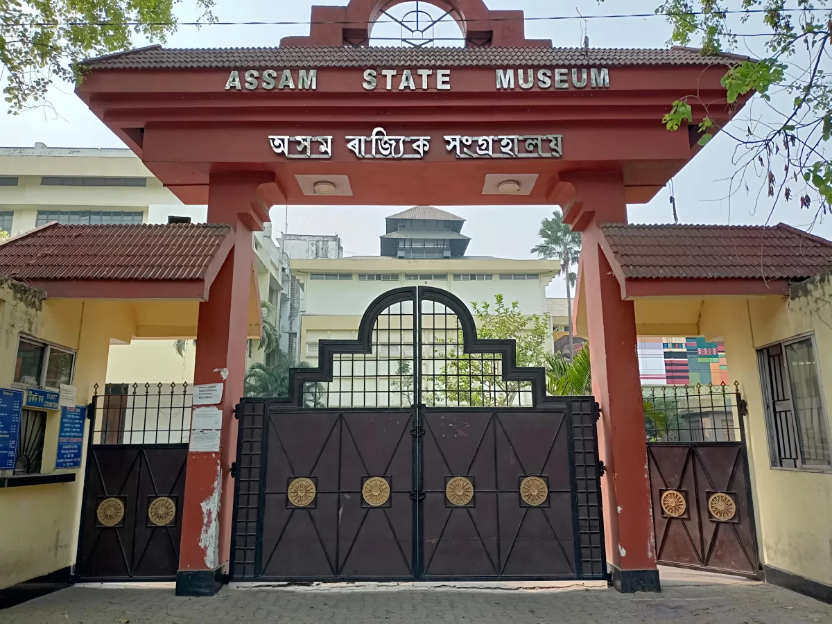 Grand torii entrance gate at Assam State Museum Guwahati during sunny day, featuring Assamese script trees gate, perfect cultural experience Assam tour package.