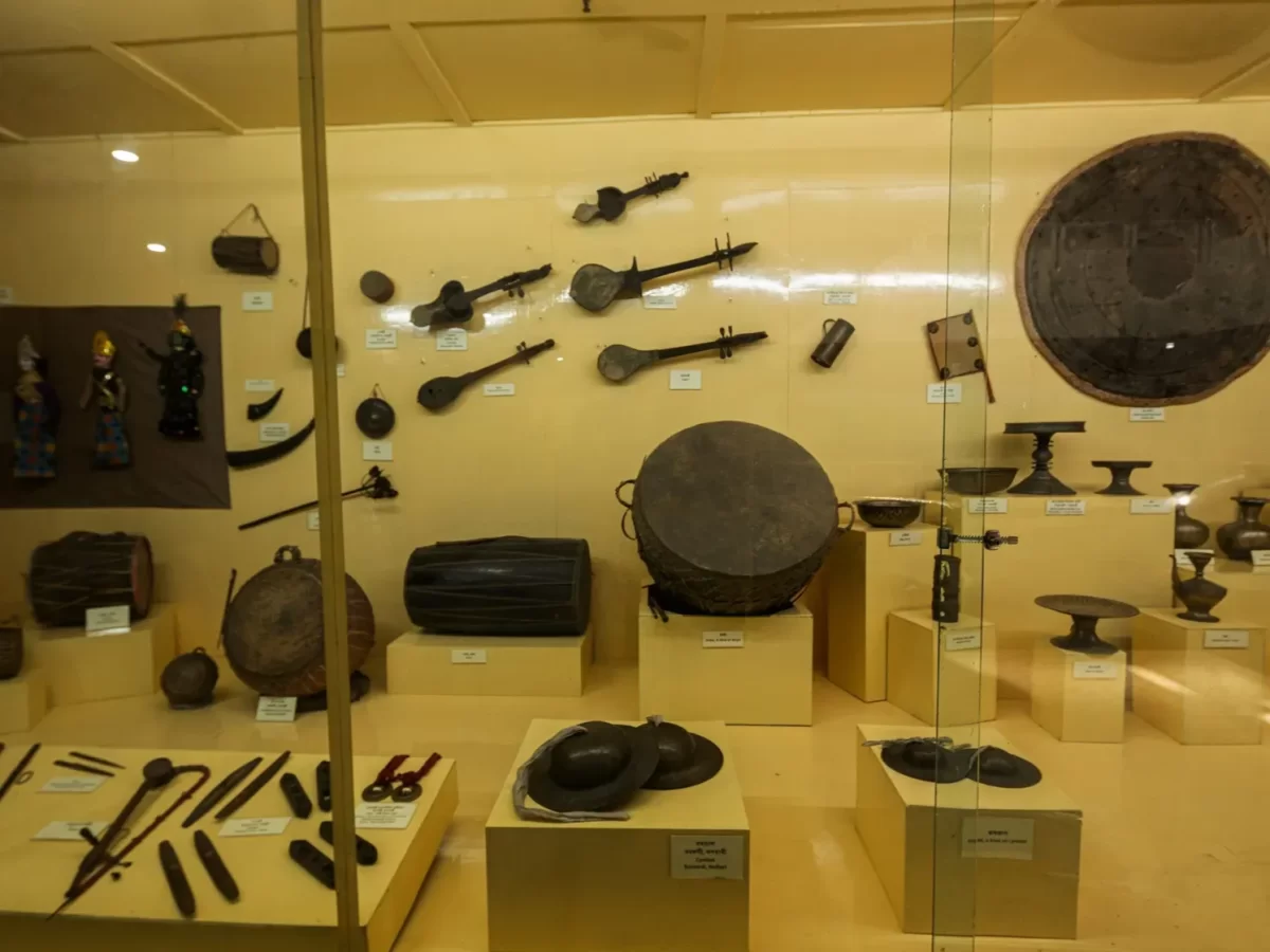 Traditional musical instruments at Assam State Museum Guwahati during daytime, featuring drums gongs flutes shields displays, perfect cultural experience Assam tour package. 