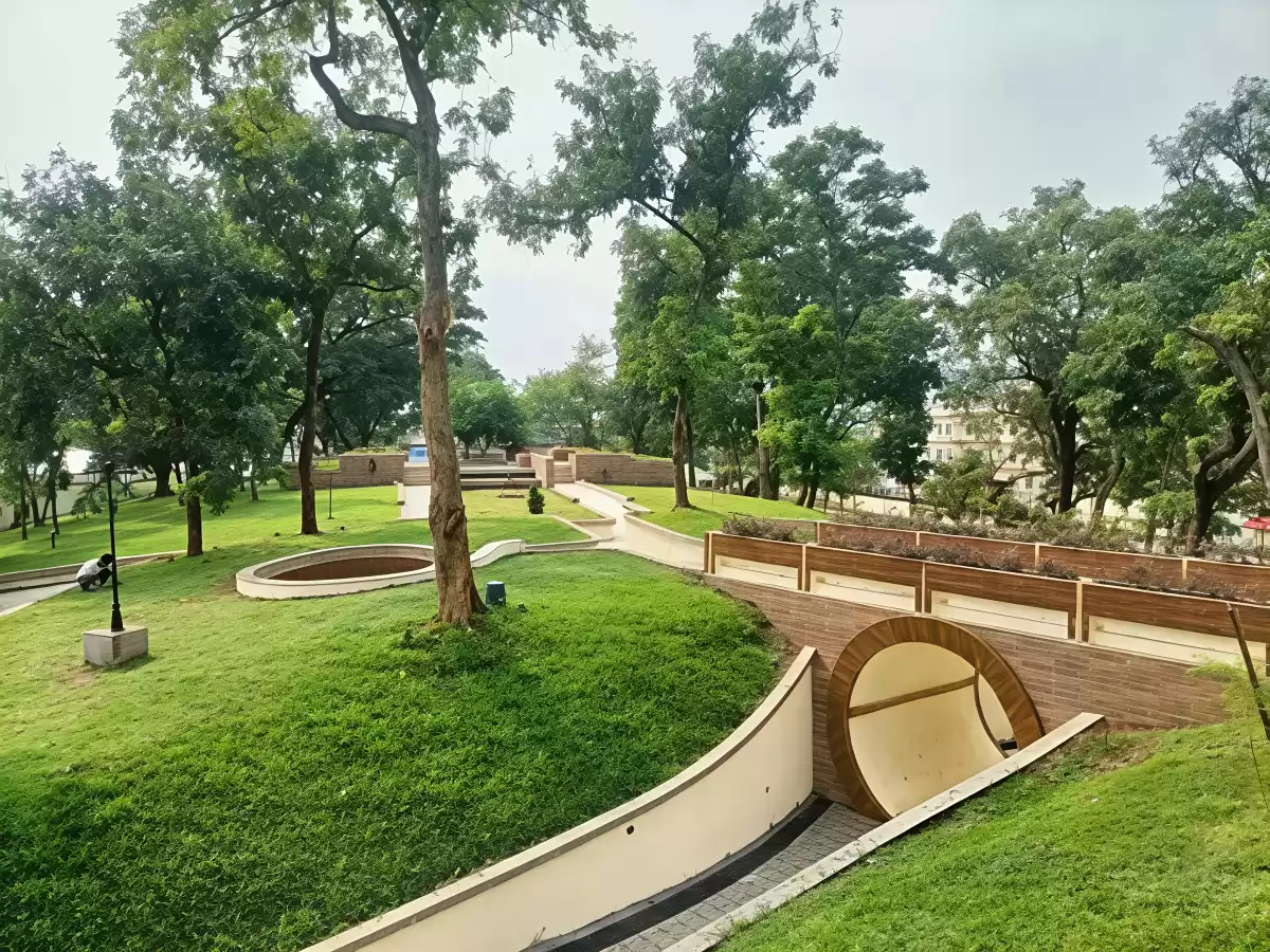 Scenic walkways at Atal Udyan Adabari Park Guwahati during cloudy day, featuring lush green lawns trees arch bridge, perfect family experience Assam tour package.