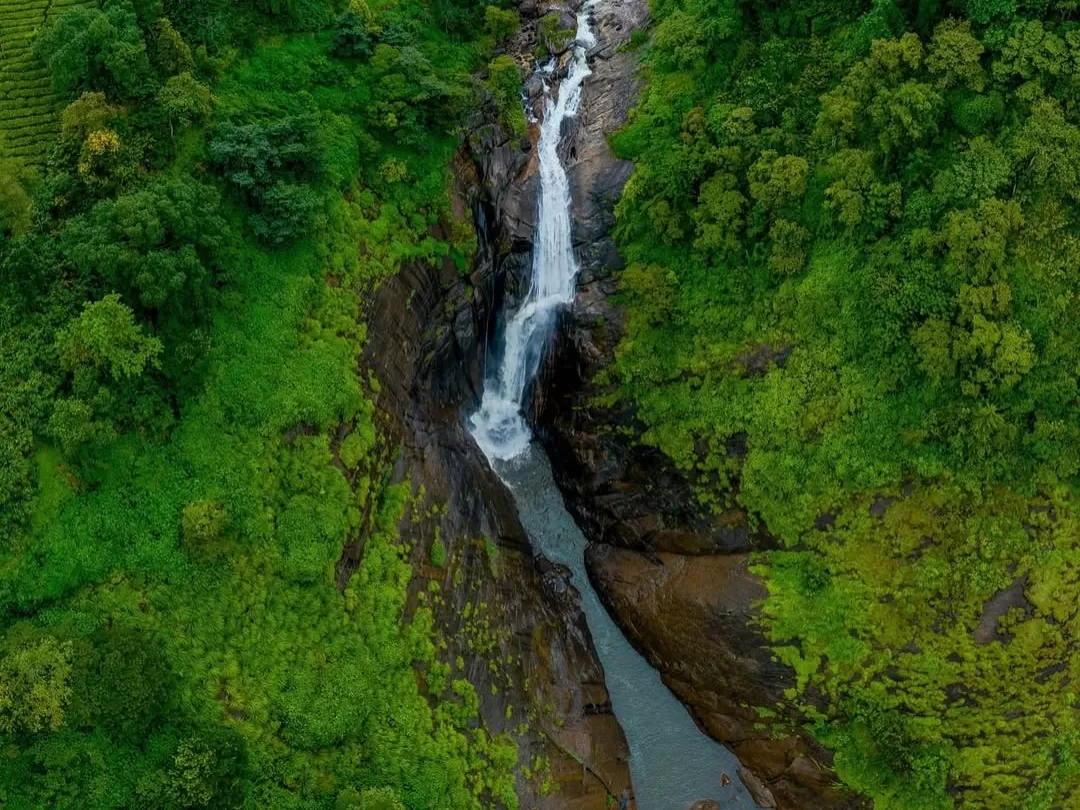 Attukad Waterfalls, Munnar Kerala cascading waterfall amid lush green hills and rocky cliffs in Western Ghats.