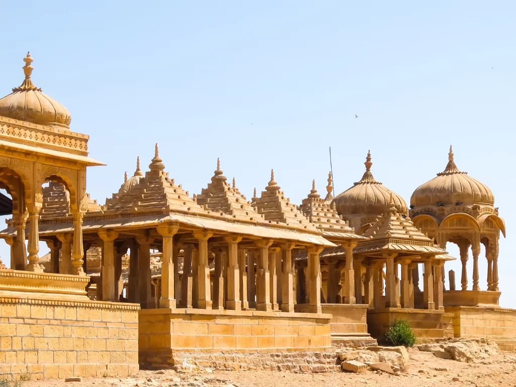 Bada Bagh Jaisalmer panoramic row of golden sandstone chhatris domes atop arid hill with sparse trees, Rajasthan Tour Packages. 
