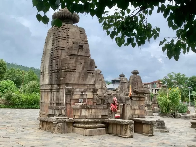 Ancient stone shrines at Baijnath Temple Complex in Baijnath, Uttarakhand surrounded by hills and greenery, a historic landmark featured in Uttarakhand tour packages