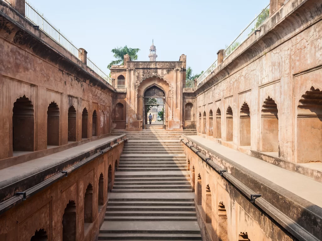 Bhool Bhulaiya labyrinth at Bara Imambara Lucknow during clear day, featuring red arches stairs minaret tower, perfect adventure Uttar Pradesh tour package.
