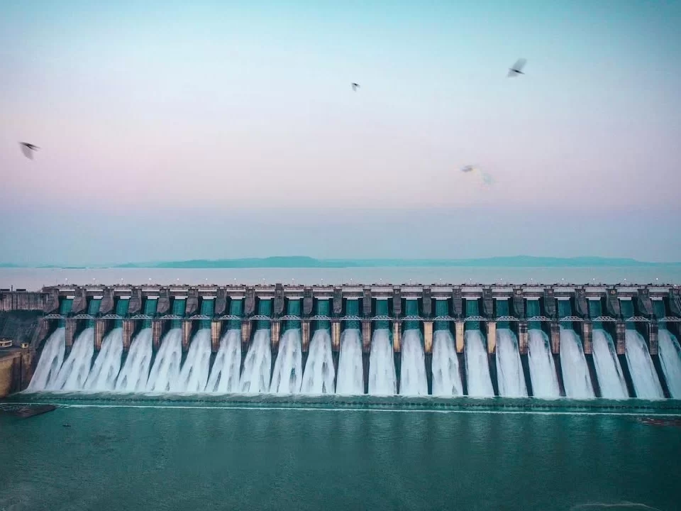 Bargi Dam and Reservoir in Jabalpur with multiple spillway gates releasing water at sunset, a scenic highlight often included in Madhya Pradesh tour packages