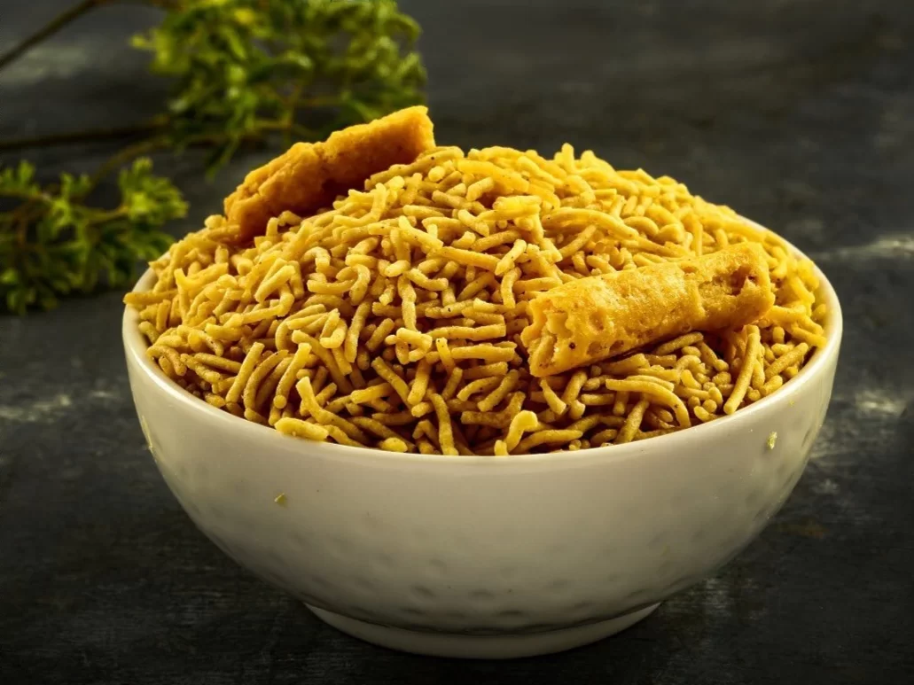 Bikaneri Bhujia in crispy spiced gram flour strands with crunchy garnish, authentic Indian namkeen snack, crunchy Indian cuisine delight.