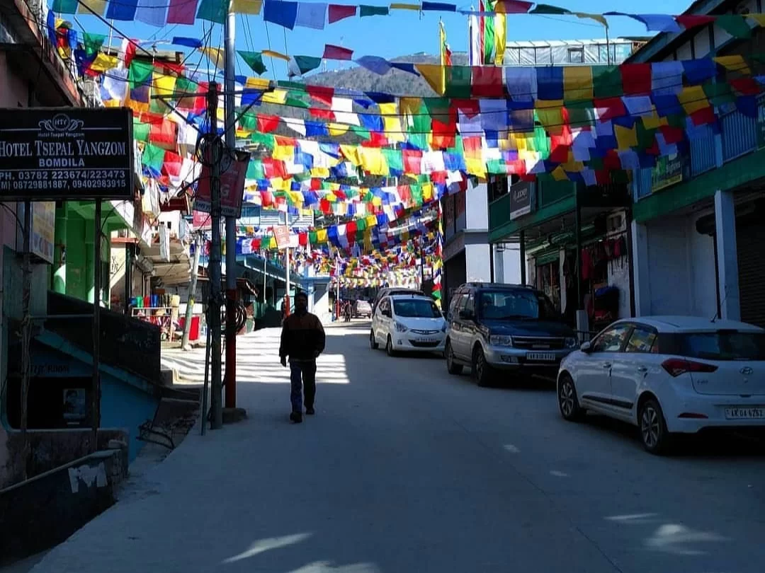 Bomdila Market vibrant local marketplace decorated with colorful prayer flags and surrounded by scenic hills in Arunachal Pradesh Package.