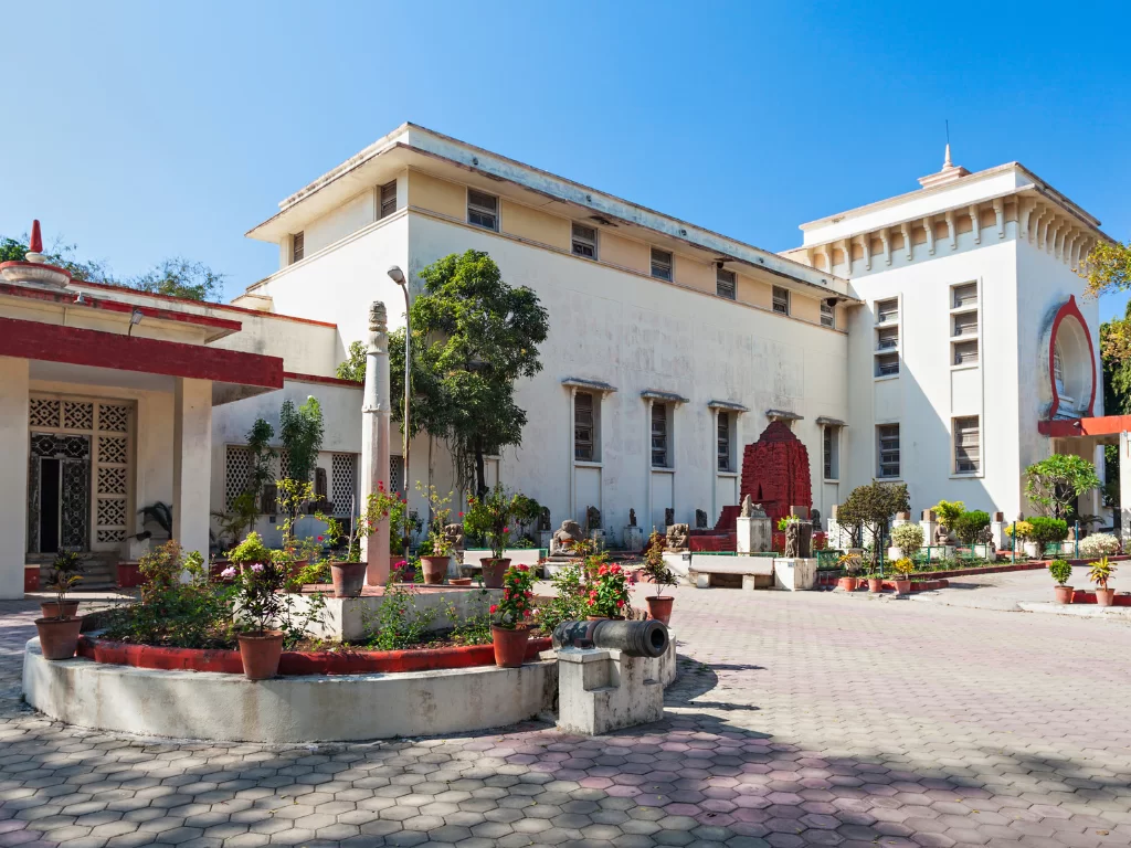Central Museum Indore Madhya Pradesh in clear daylight, featuring white building with temple tower, gardens and plants, perfect cultural Madhya Pradesh tour package.