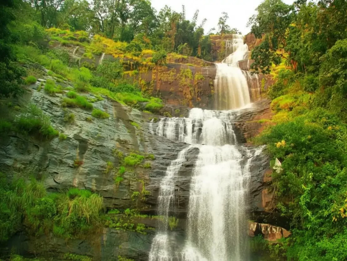 Cheyyappara Waterfall in Kerala, multi-tier cascading waterfall amid lush greenery and rocky cliffs.