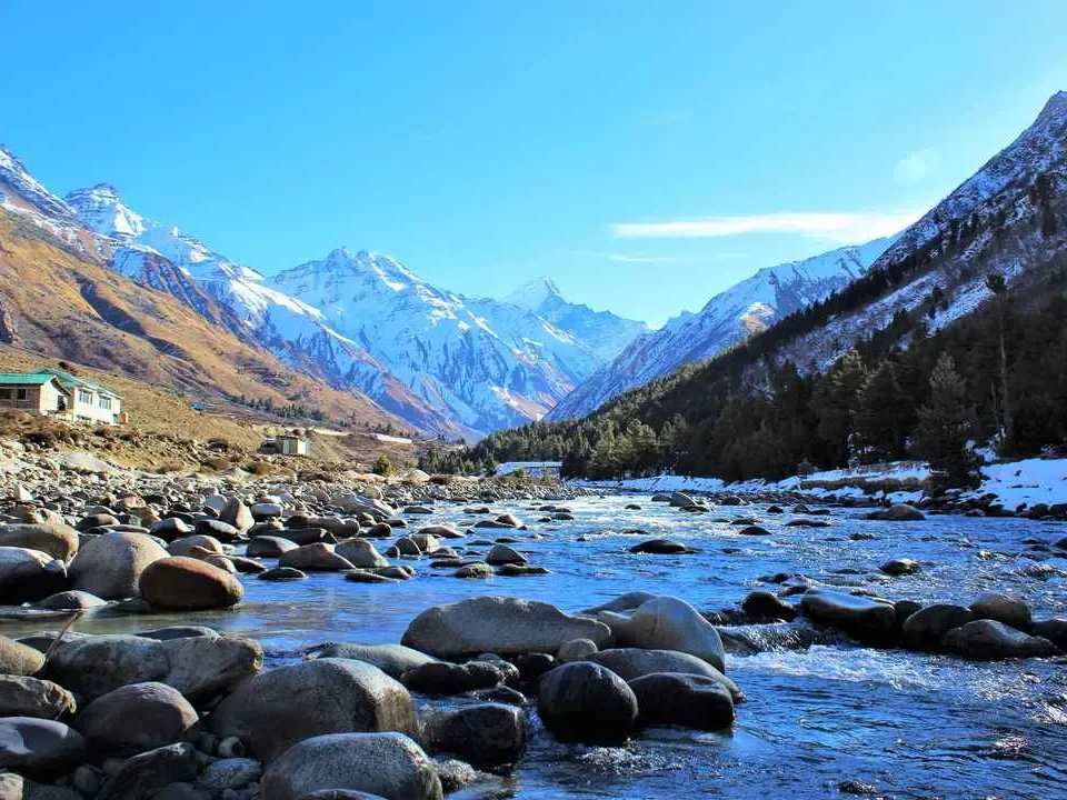 Chitkul Suspension Bridge Baspa River Chitkul Village Kinnaur Himachal Pradesh aerial view turquoise rapids pine meadows terraced fields red truss structure, perfect cultural experience Himachal tour package.