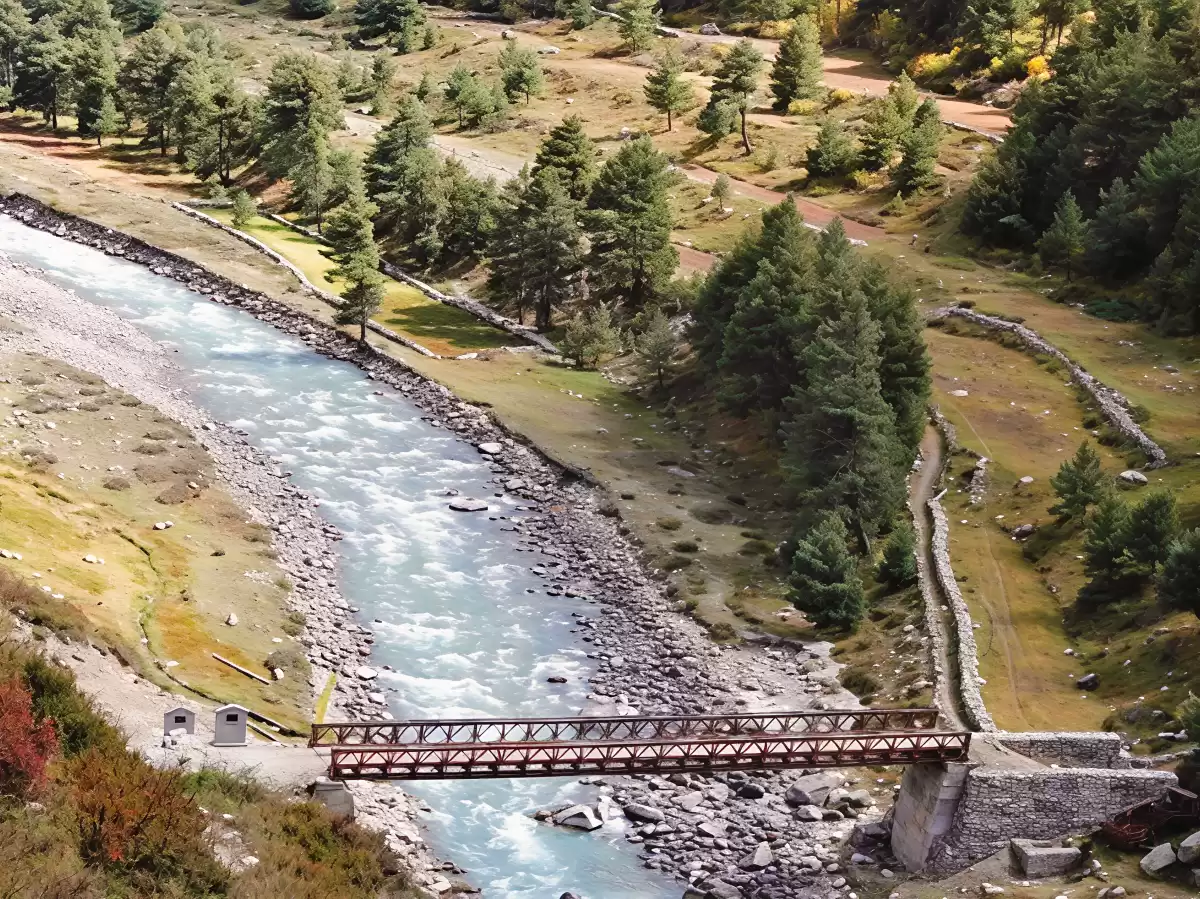 Chitkul Suspension Bridge Baspa River Chitkul Village Kinnaur Himachal Pradesh aerial view turquoise rapids pine forested meadows rocky banks red truss, perfect cultural experience Himachal tour package.