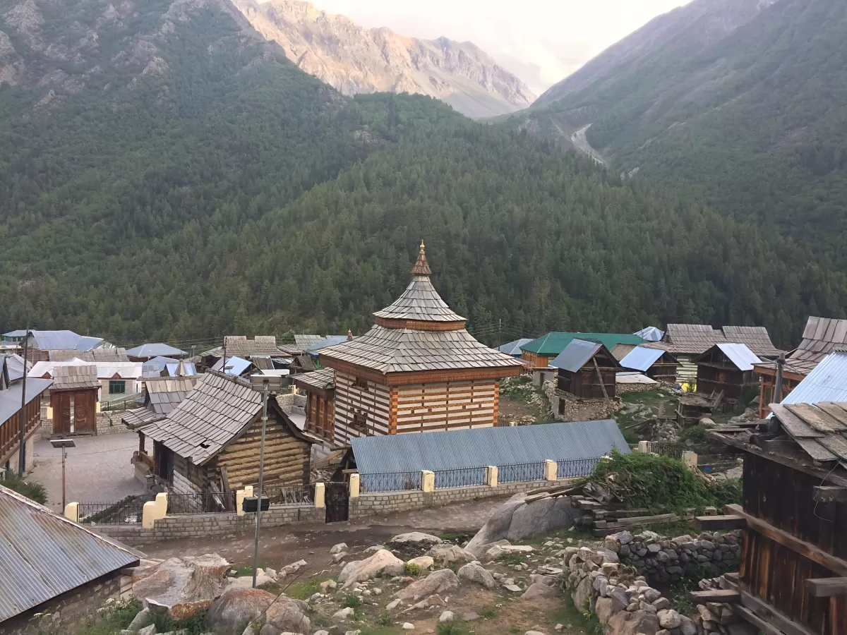 Chitkul Village Kinnaur Himachal Pradesh during golden hour sunset, featuring wooden temple cluster traditional houses forested mountain valley backdrop, perfect cultural experience Himachal tour package.