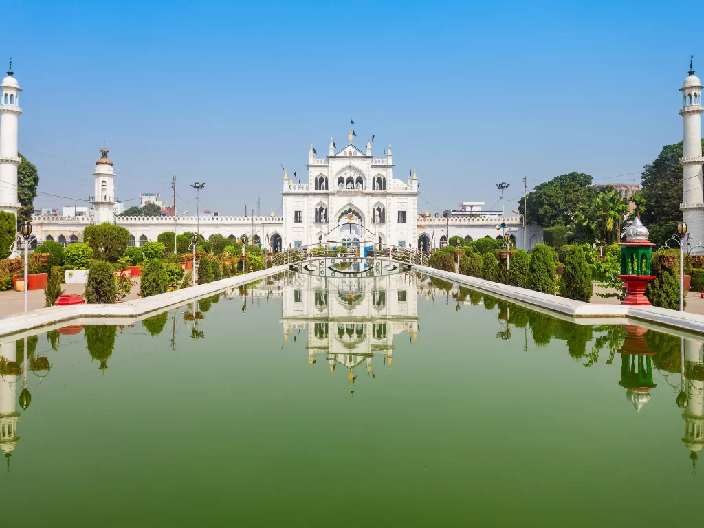Chota Imambara reflection in pool at Lucknow during blue sky day, featuring domes minarets gardens fountain, perfect cultural Uttar Pradesh tour package.