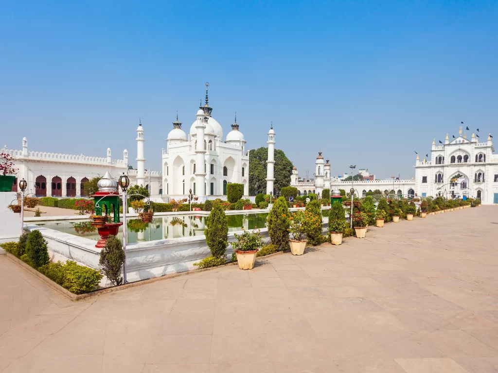Chota Imambara complex at Lucknow during clear day, featuring white domes fountain gardens lamps, perfect cultural Uttar Pradesh tour package.