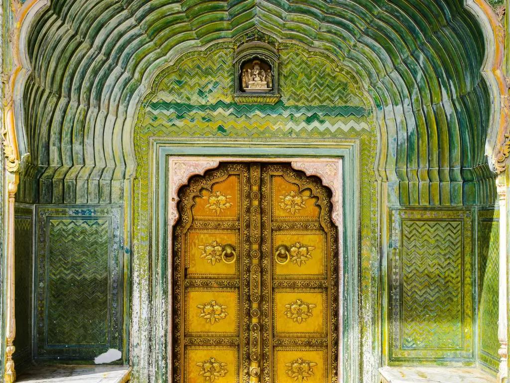 Leheriya Green Gate or Vatika Gate at Pritam Niwas Chowk City Palace Jaipur Rajasthan with green tile waves zigzag patterns golden carved wooden doors Ganesha idol above pink borders, perfect Rajasthan tour package.
