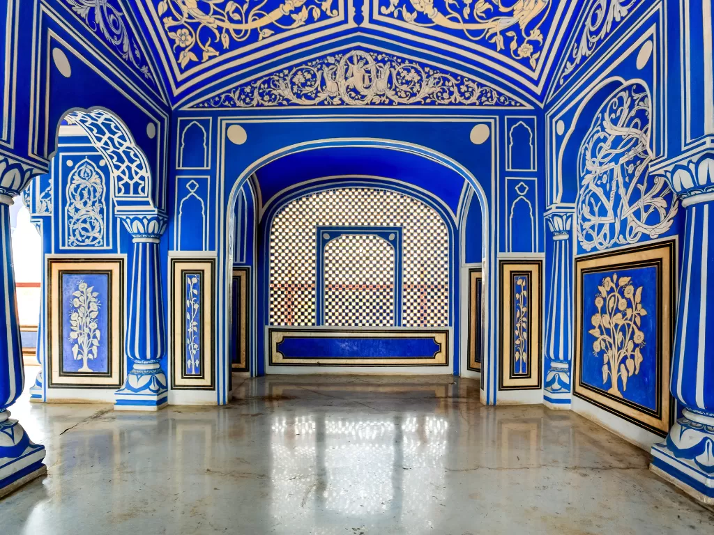 Stunning blue Pritam Chowki hall at City Palace Jaipur Rajasthan with gold leaf tree murals jali screen central throne intricate carvings polished marble floor Rajasthani artistry, perfect Rajasthan tour package.
