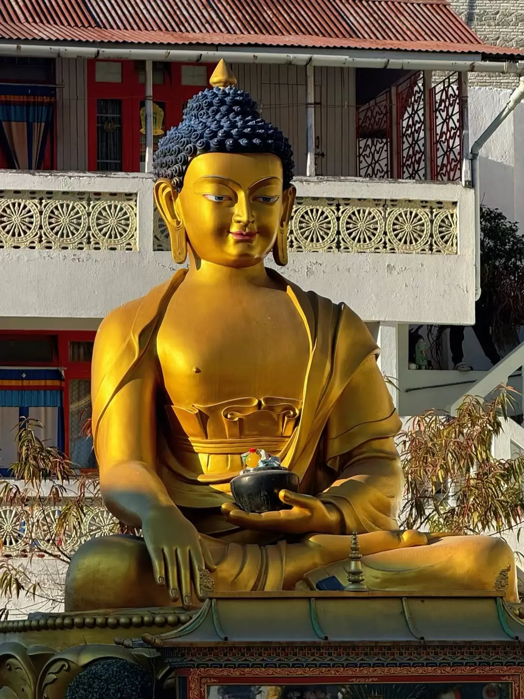Golden Buddha statue seated in meditation at a monastery in Darjeeling, a spiritual landmark often included in West Bengal tour packages.