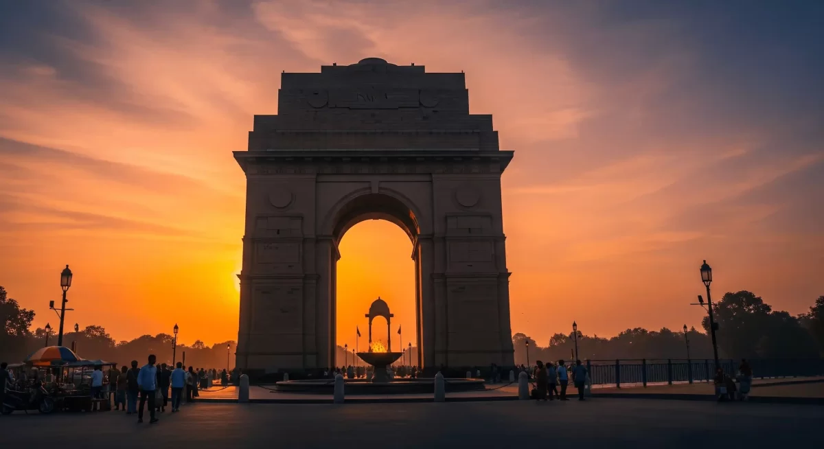 India Gate at Delhi during vibrant sunset, featuring lamp posts and crowds, perfect romantic Delhi tour package.