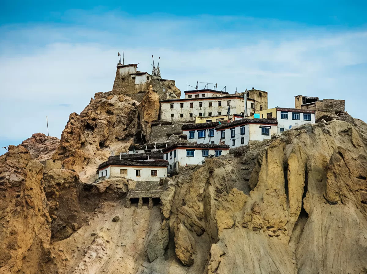 Dhankar Monastery near Kaza Spiti Valley Himachal Pradesh during partly cloudy skies, featuring white multi-tiered cliffside gompa rocky outcrops blue sky, perfect cultural experience Himachal tour package.