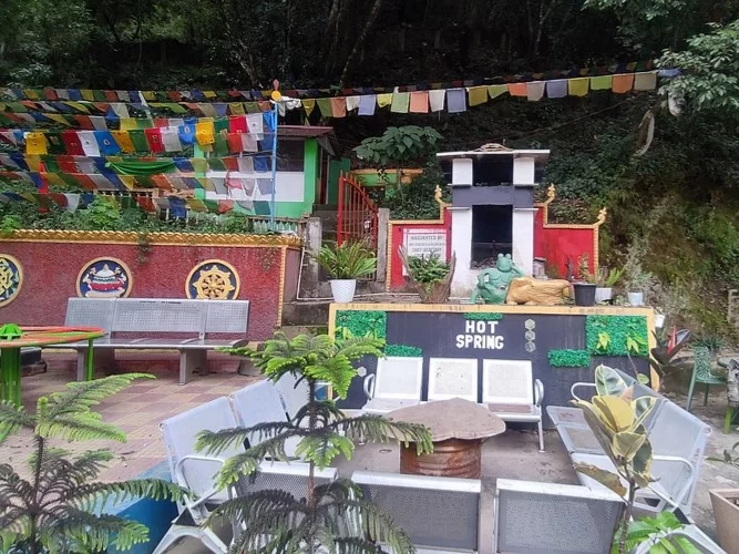 Dirang Hot Water Spring in Arunachal Pradesh natural thermal bath surrounded by prayer flags and hills