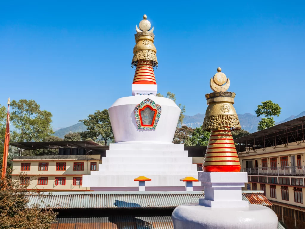 White Do Drul Chorten stupa in Gangtok during sunny daytime, featuring golden spires and blue sky backdrop, perfect spiritual Sikkim tour package