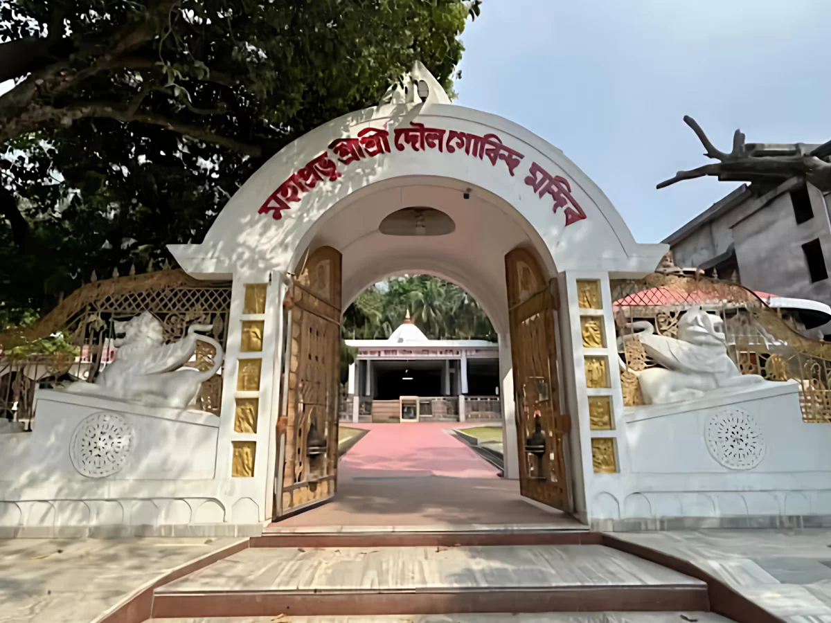 Entrance gate of Doul Govinda Temple in North Guwahati during sunny day, featuring white arch, lion statues and pathway, perfect spiritual experience Assam tour package.