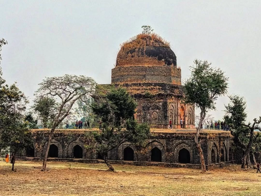 Historic stone pavilion at Echo Point in Mandu, Madhya Pradesh, surrounded by open grounds and arched architecture, a scenic heritage site often included in Madhya Pradesh tour packages