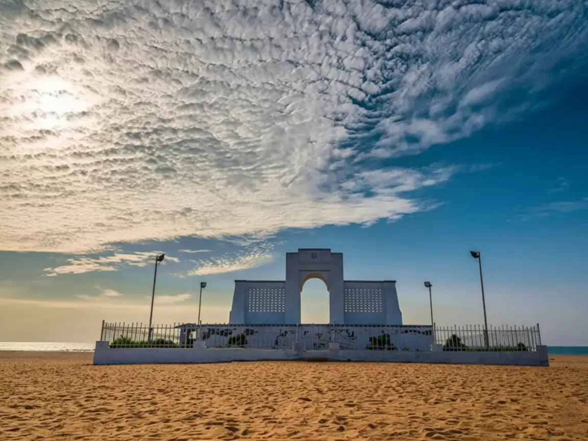 Edward Elliot's Beach in Besant Nagar featuring the Karl Schmidt Memorial on a sandy shoreline with blue waves.
