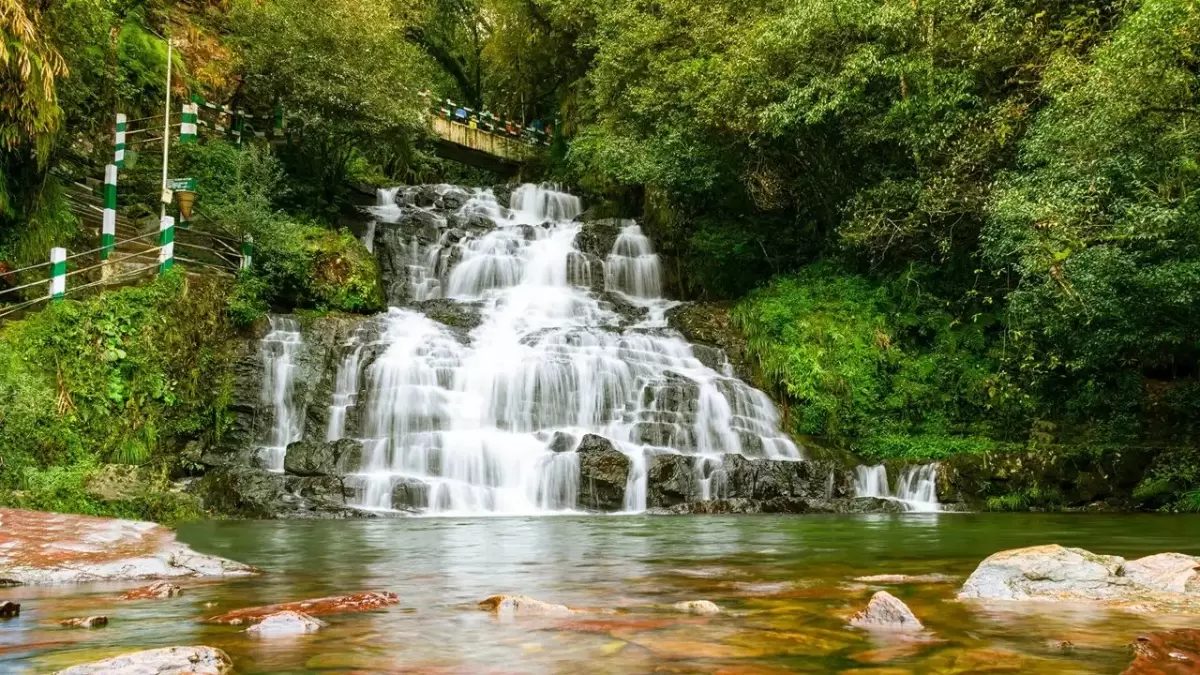 Elephant Falls in Shillong, multi-tiered waterfall cascading through lush green forest landscape.