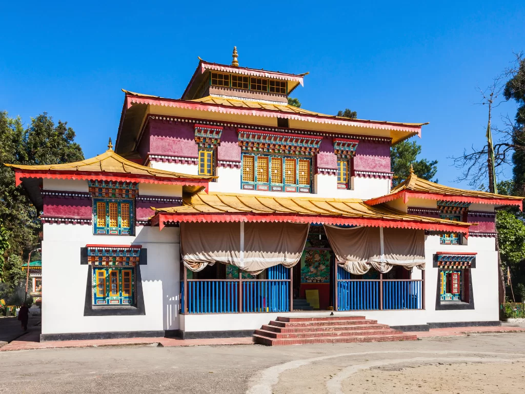 Colorful Buddhist prayer at Enchey Monastery in Gangtok during clear daytime, featuring vibrant Tibetan architecture, perfect spiritual experience Sikkim tour package