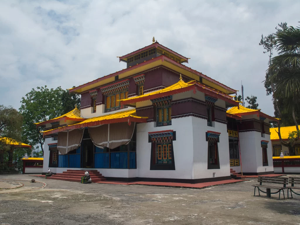 Colorful Enchey Monastery in Gangtok during cloudy daytime, featuring traditional Tibetan architecture and courtyard, perfect spiritual experience Sikkim tour package