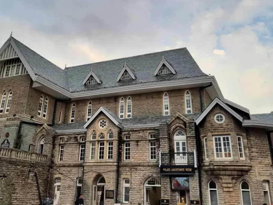 Gaiety Heritage Cultural Complex Shimla Gothic stone facade with arched windows balcony gables cloudy backdrop, ideal heritage theatre landmark, Himachal Pradesh tour packages.