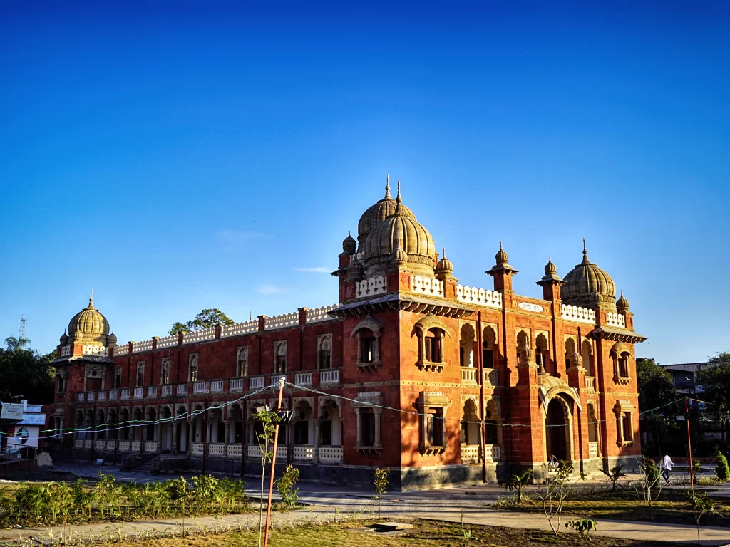Mahatma Gandhi Hall at Indore in golden sunset light, featuring red sandstone domes and arches, perfect cultural experience Madhya Pradesh tour package.