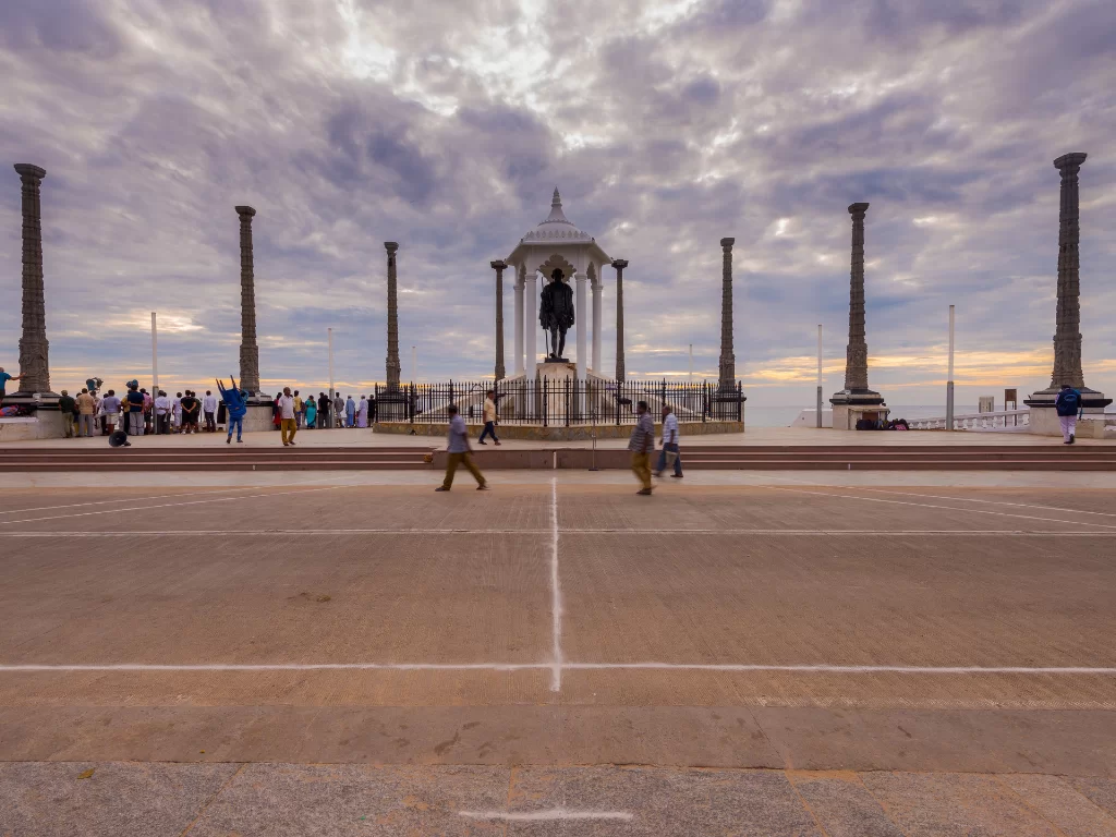 Mahatma Gandhi statue at Promenade Beach Puducherry during sunset clouds, featuring granite pillars and pavilion, perfect cultural experience Puducherry tour package.