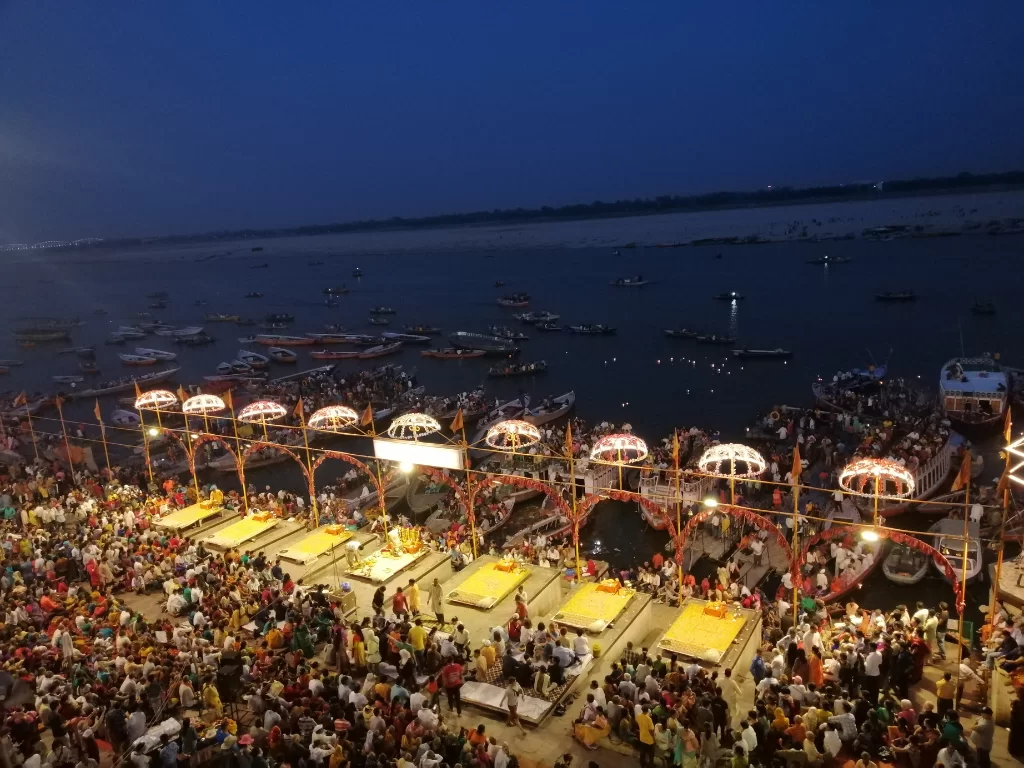 Ganga Aarti at Varanasi ghats during night, featuring lamps crowds boats river views, perfect spiritual Uttar Pradesh tour package.