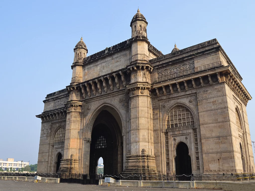 Gateway of India early morning view with empty plaza, highlighting the grand Indo-Saracenic stone arch, domed turrets, and iconic waterfront landmark of South Mumbai tourism.